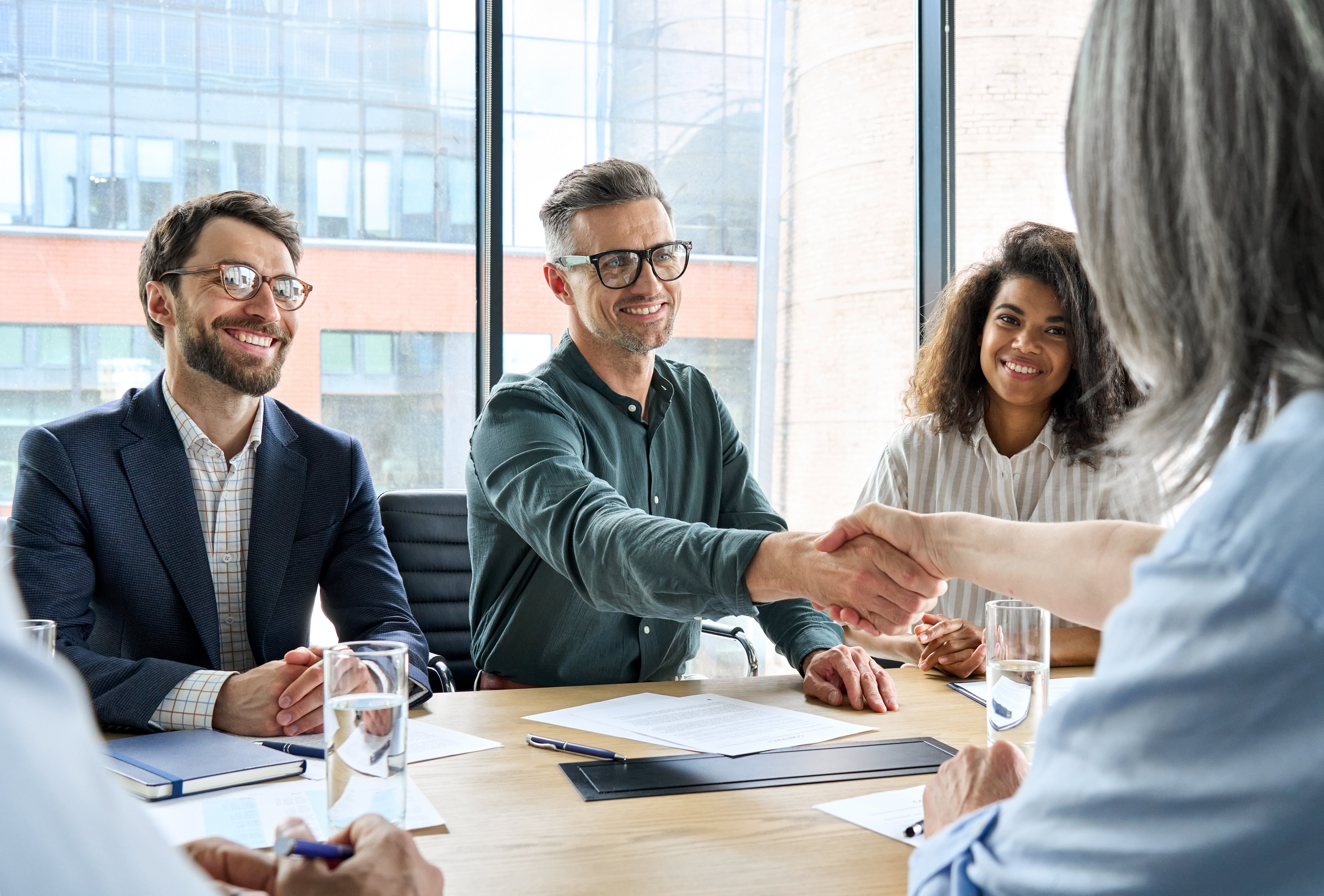 Table of professionals discussing and shaking hands
